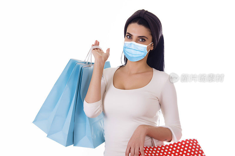 Young woman in medical mask holding shopping bag, white backgrounds, Sales and discounts during COVID-19 quarantine